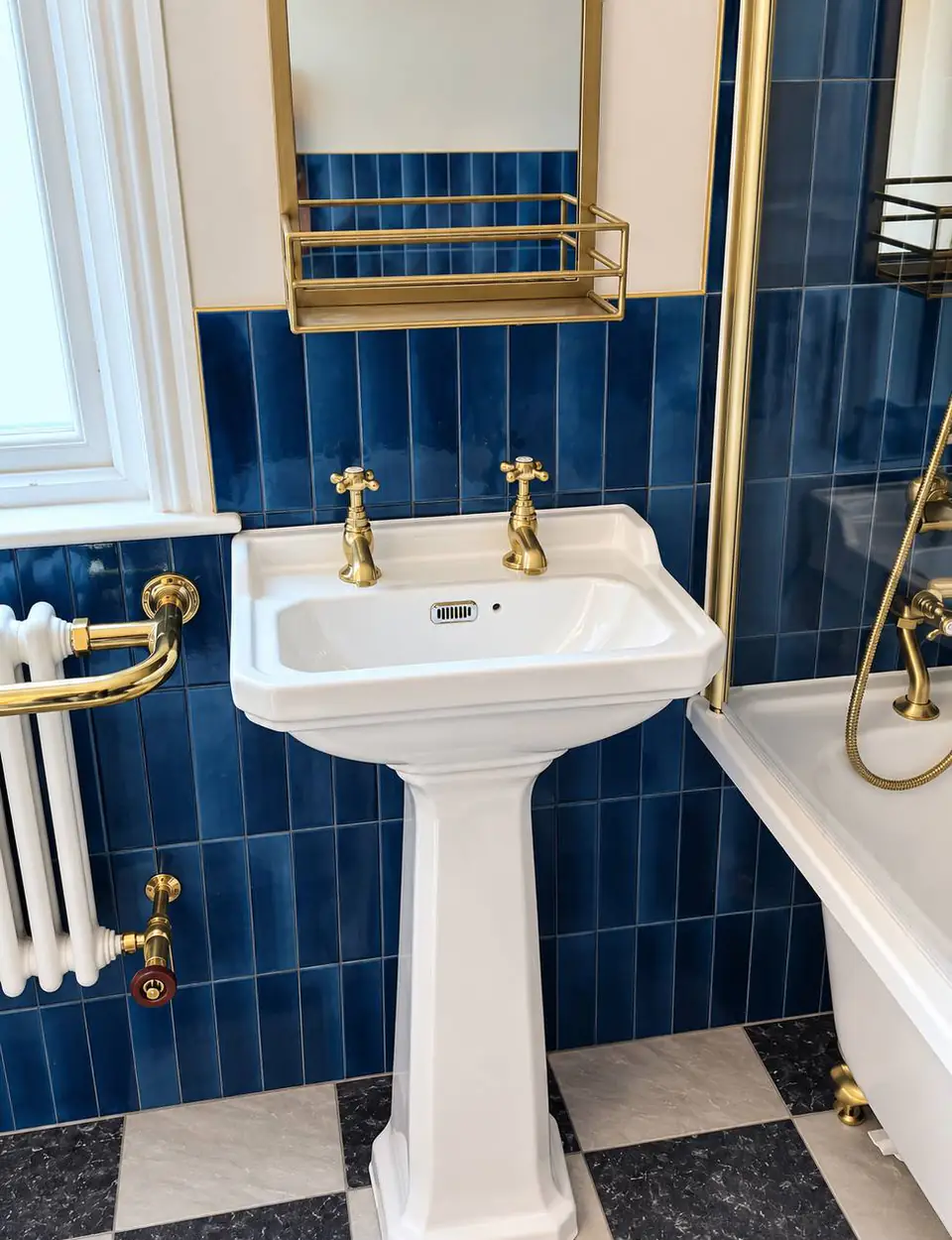 Pedestal basin with brass cross-head taps, a brass shelf and a white column radiator