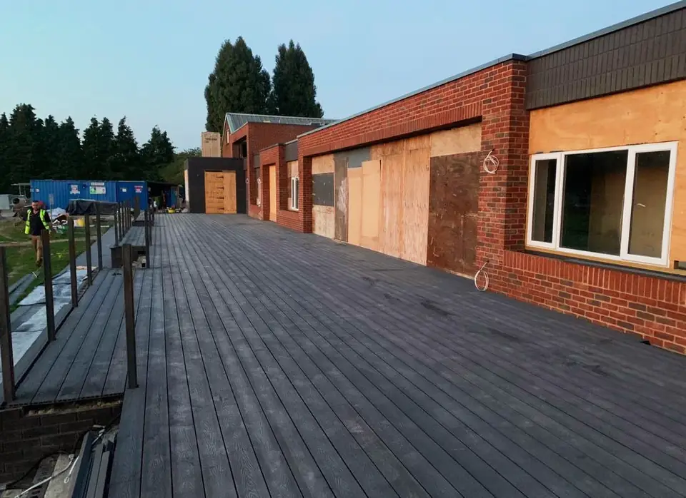 Finished dark decking boards along a brick building, London project