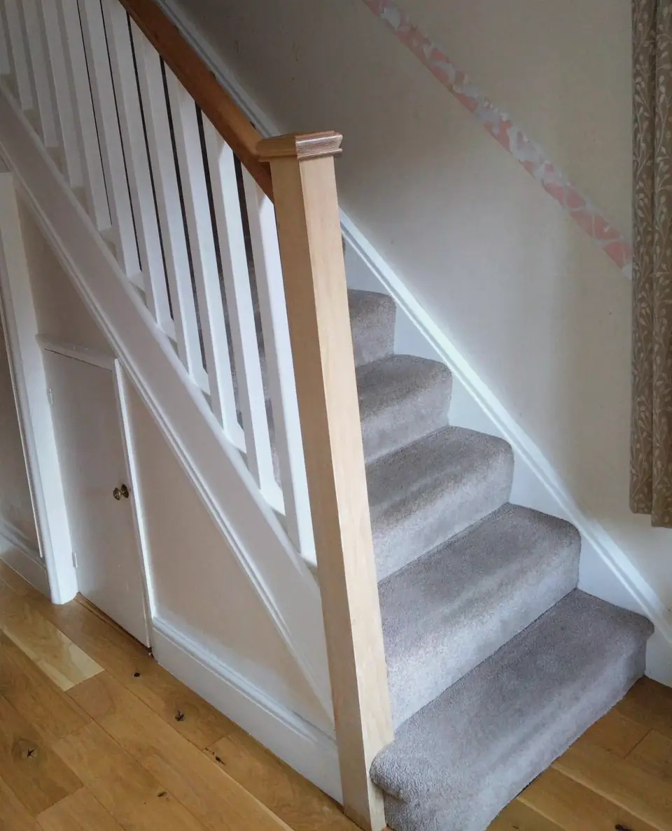 Staircase with a timber handrail, newel post and white spindles