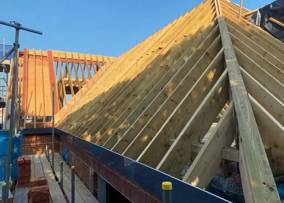 Timber rafters and sheathing on a large pitched roof, London project
