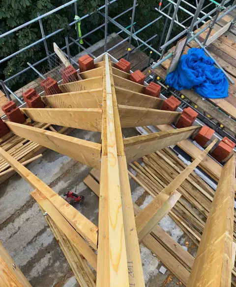 Timber hip rafters meeting at the ridge of a new roof, London project